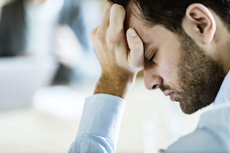 Un homme d'affaires ayant mal à la tête au bureau.